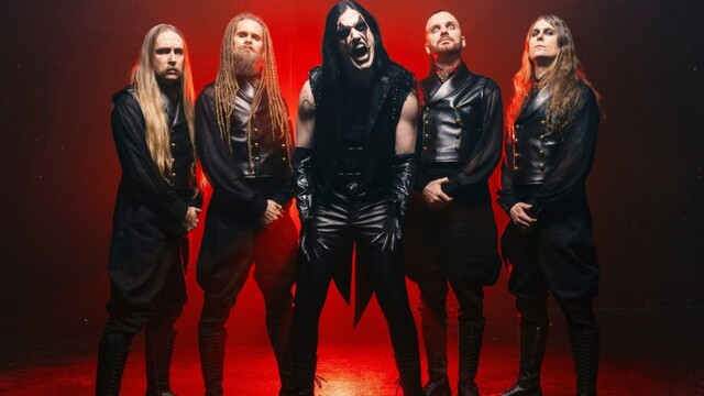 Die Band steht vor einem Rot beleuchteten Hintergrund