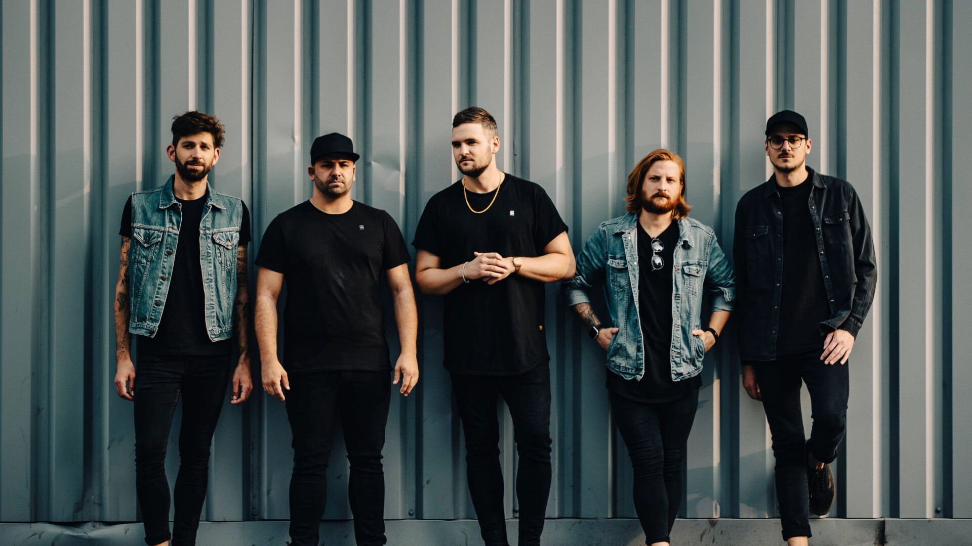 Die Band All Faces Down steht zu fünft vor Container