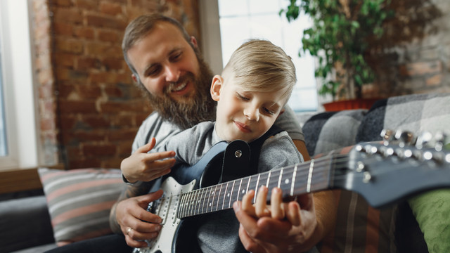 Vater und Sohn mit einer E-Gitarre
