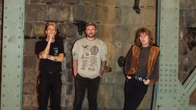 Anda Morts stehen vor einer Wand zwischen Stahlpfeilern