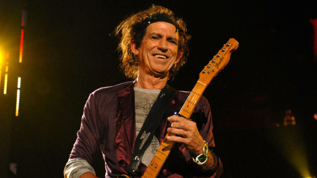 Keith Richards spielt Gitarre auf der Bühne und lacht