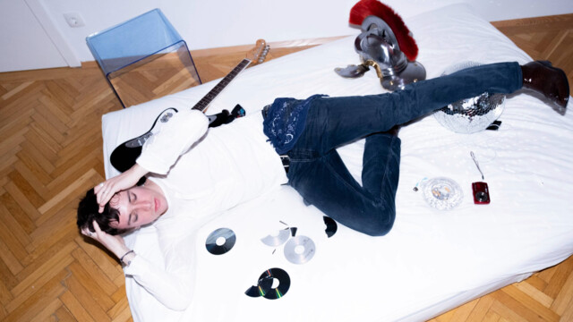 Fiio liegt auf einer weißen Matratze mit CDs und einem Helm mit Crista Centurio Helm