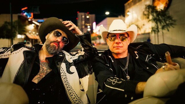 die 2 Musiker von The BossHoss sitzen in einem Cabrio und tragen Cowboy Hüte