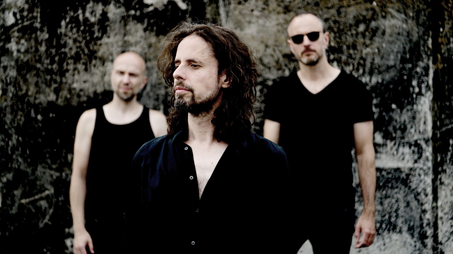 Bandfoto von Forced To Mode, alle drei Mitglieder tragen schwarz