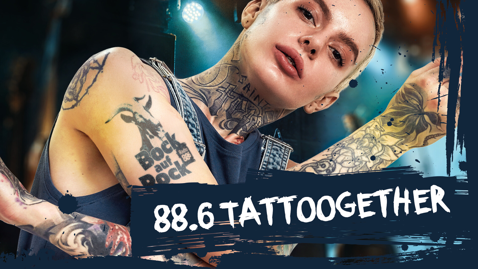 eine Frau mit Tattoos auf Hals und Armen dem Bock auf Rock Tattoo am Oberarm